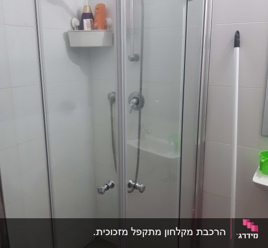 מקלחון זכוכית פינתי מתקפל עם דלתות אקורדיון בחדר רחצה